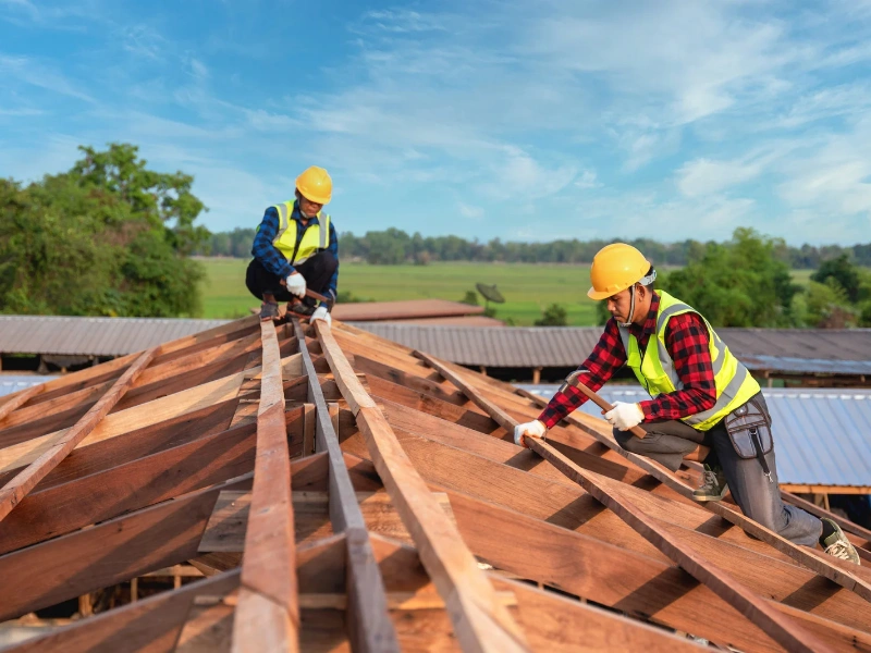 Image of multiple workers on the job site of a residential home replacing a roof.
